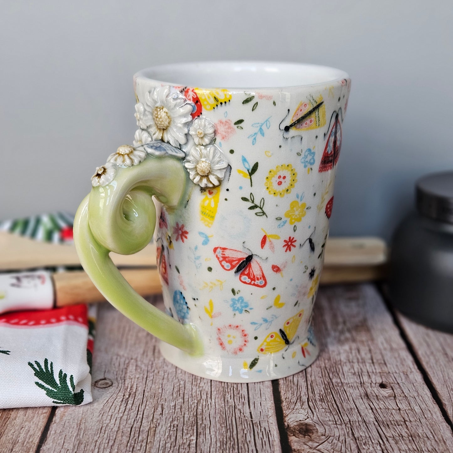 Yellow-Green and white floral and butterfly mug with pigtail handle