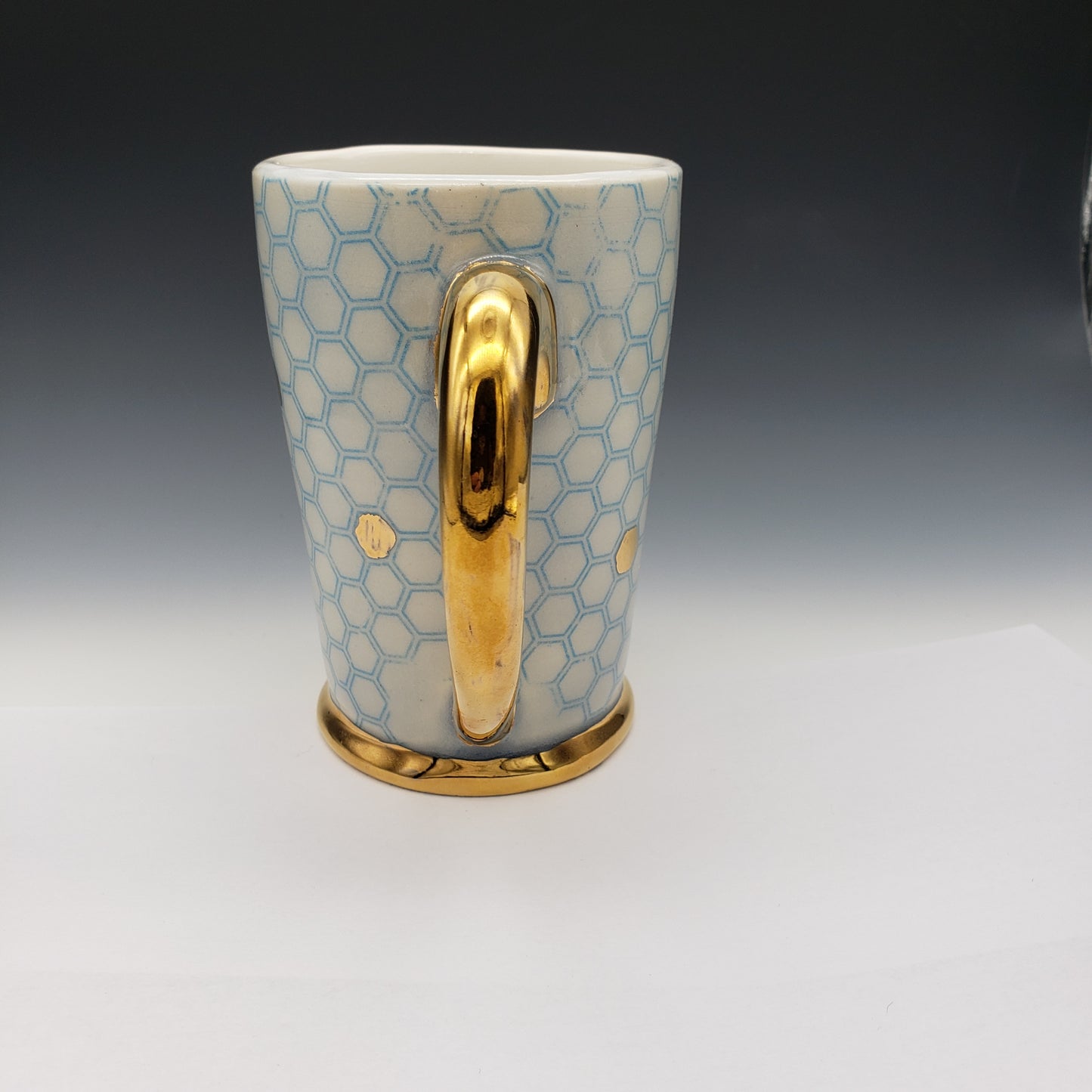 Blue and white honeycomb mug with 14k yellow gold on the handle and base.